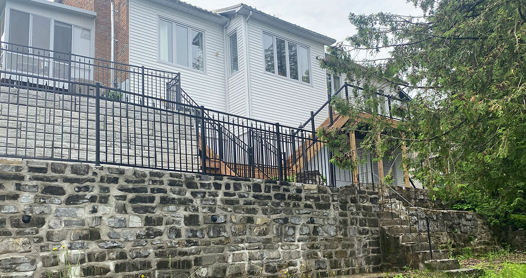 Retaining Wall With Wrought Iron Fence & Wooden Steps With Railings